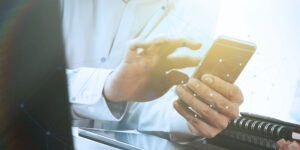 Businessman hand using laptop and mobile phone mobile device management