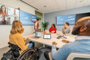 people sitting around large meeting room using Poly Studio Zoom Room bundle