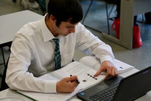 student studying or reading with laptop in front of him, ConnectWise and COMPTIA Ticket to Tech career training initiative