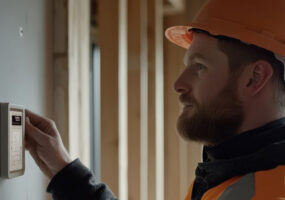construction worker working on thermostat, IoT devices, campus networks, data breaches